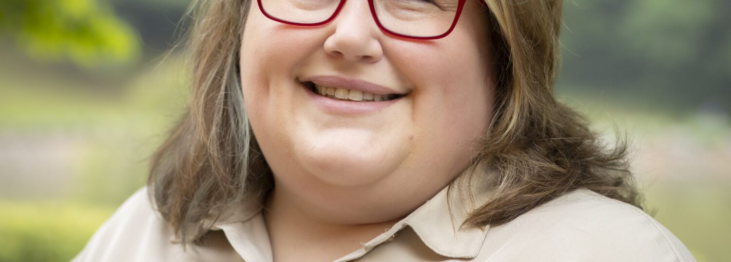 Headshot of Robinson wearing a camel colored button up.