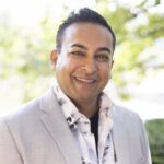 Headshot of Sathy wearing a light colored blazer.