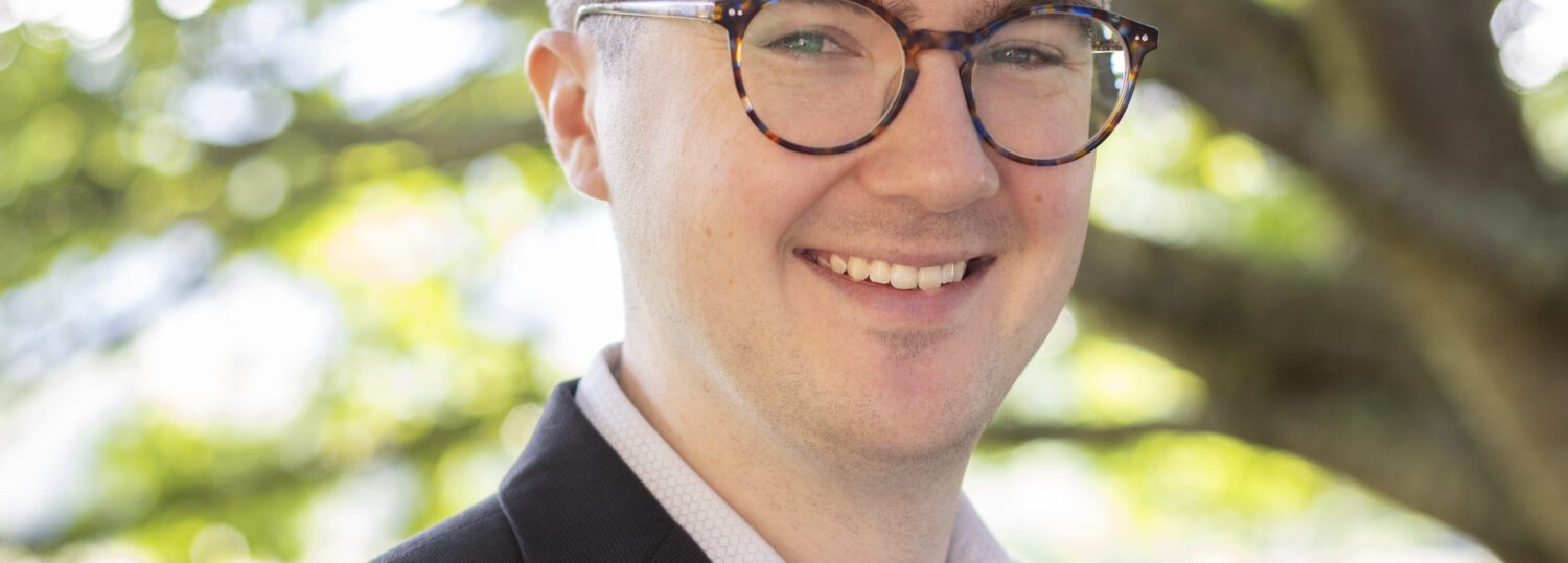 Headshot of Steitz wearing a black blazer over a light colored button up shirt.
