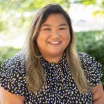 Headshot of Mitchell wearing a black and white patterned blouse.